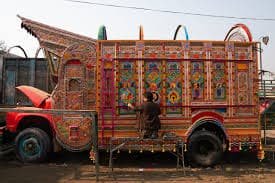 An artist painting a truck. 