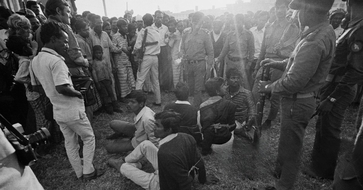Five prisoners sit, roped together at a political rally in Dhaka, Bangladesh, two days after the Pakistani surrender at the end of the Bangladesh War of Independence, 18th December 1971. They are accused of being members of the pro-Pakistani Razakar paramilitary force. They are about to be beaten, tortured, and executed by the Guerrillas of the pro-independence Mukti Bahini forces.