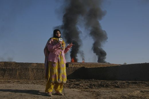 Reporter reporting in front of rising smoke