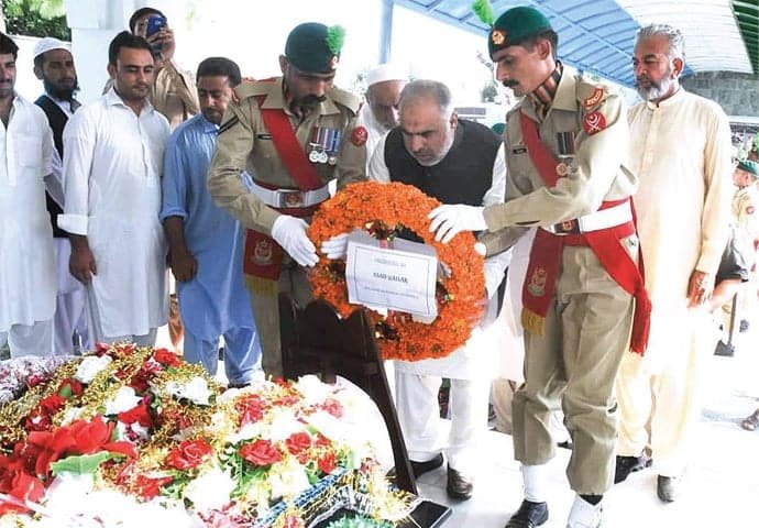Govt official presenting flowers on Shaheed's memorial 