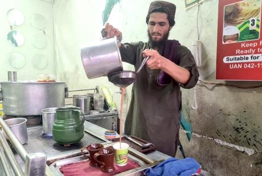 a person making tea at tea stall