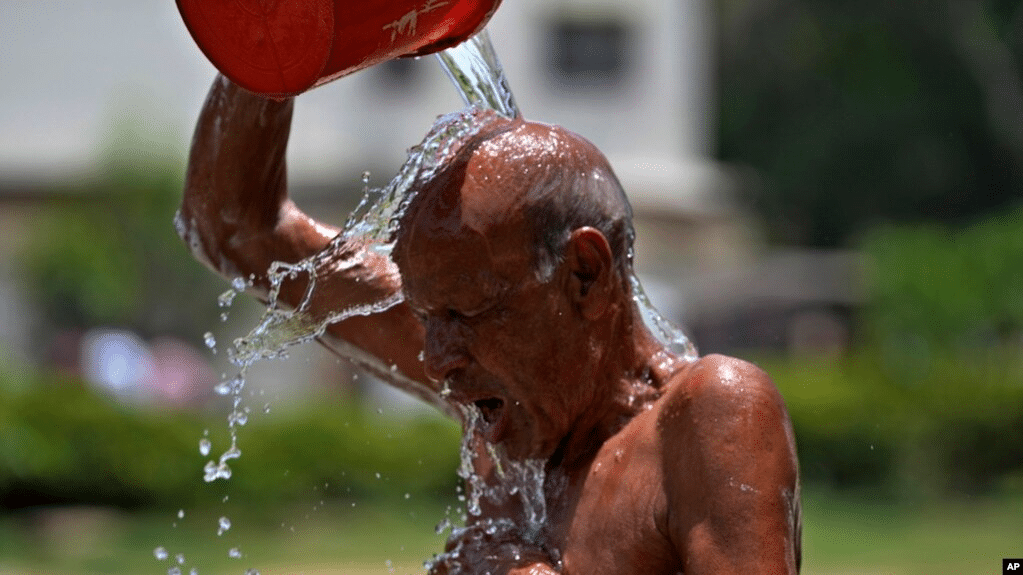 A man pours water on himself during a hot summer day at a park in Karachi, Pakistan, May 21, 2024.