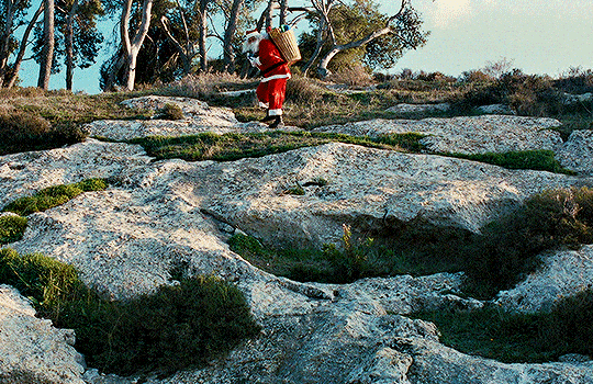 The gif showcases Santa throwing confetti. 